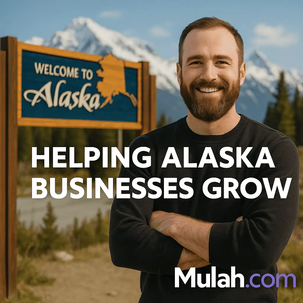 Smiling Alaska small business owner standing in front of a Welcome to Alaska sign with text overlay ‘Helping Alaska Businesses Grow’ and Mulah.com logo.