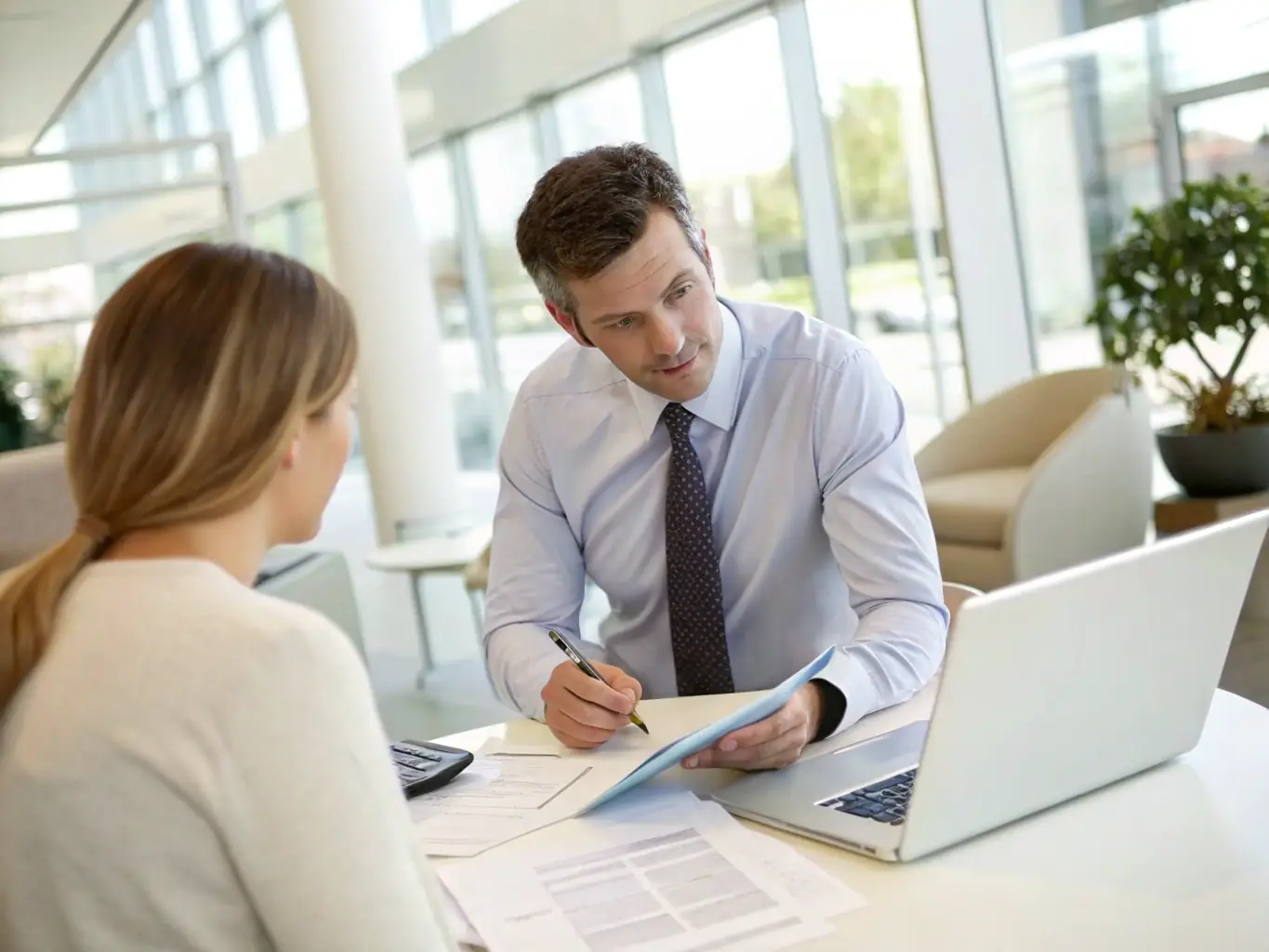 A professional banker in a modern office setting, reviewing financial documents with a focused expression, symbolizing trust and expertise.
