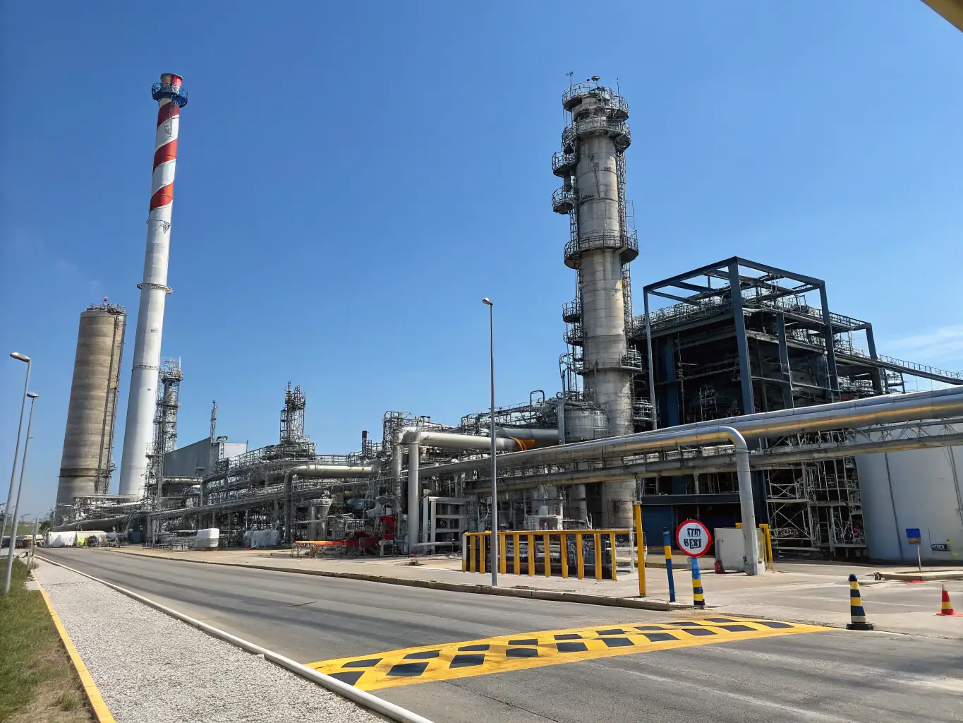An aerial view of a large chemical plant with storage tanks and pipelines, emphasizing the scale and infrastructure of the chemical industry. The image should convey a sense of stability and growth.