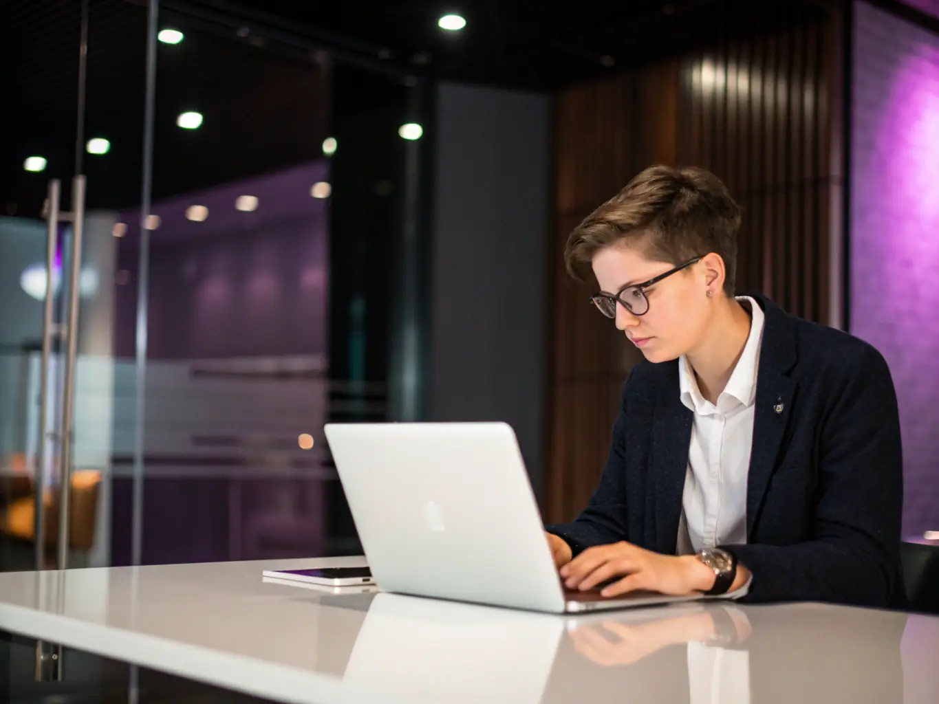 A person is filling out an online application form on a laptop, with a focused expression, in a modern office setting. The Mulah logo is subtly visible in the background.
