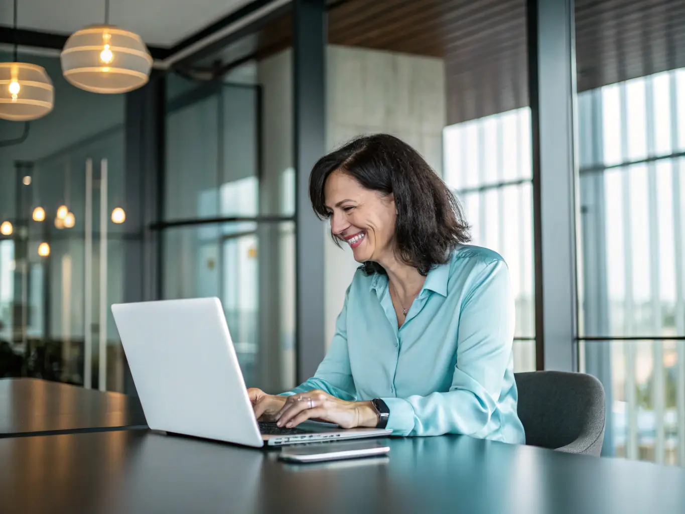 A consultant working on a laptop in a bright, modern office, representing the use of funding for professional development and training.