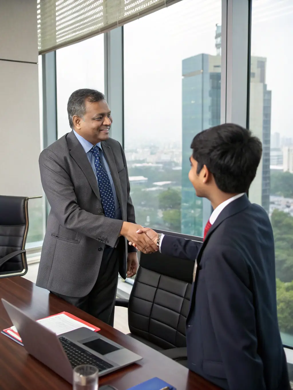 A telecom executive shaking hands with a Mulah representative, symbolizing a successful funding partnership.