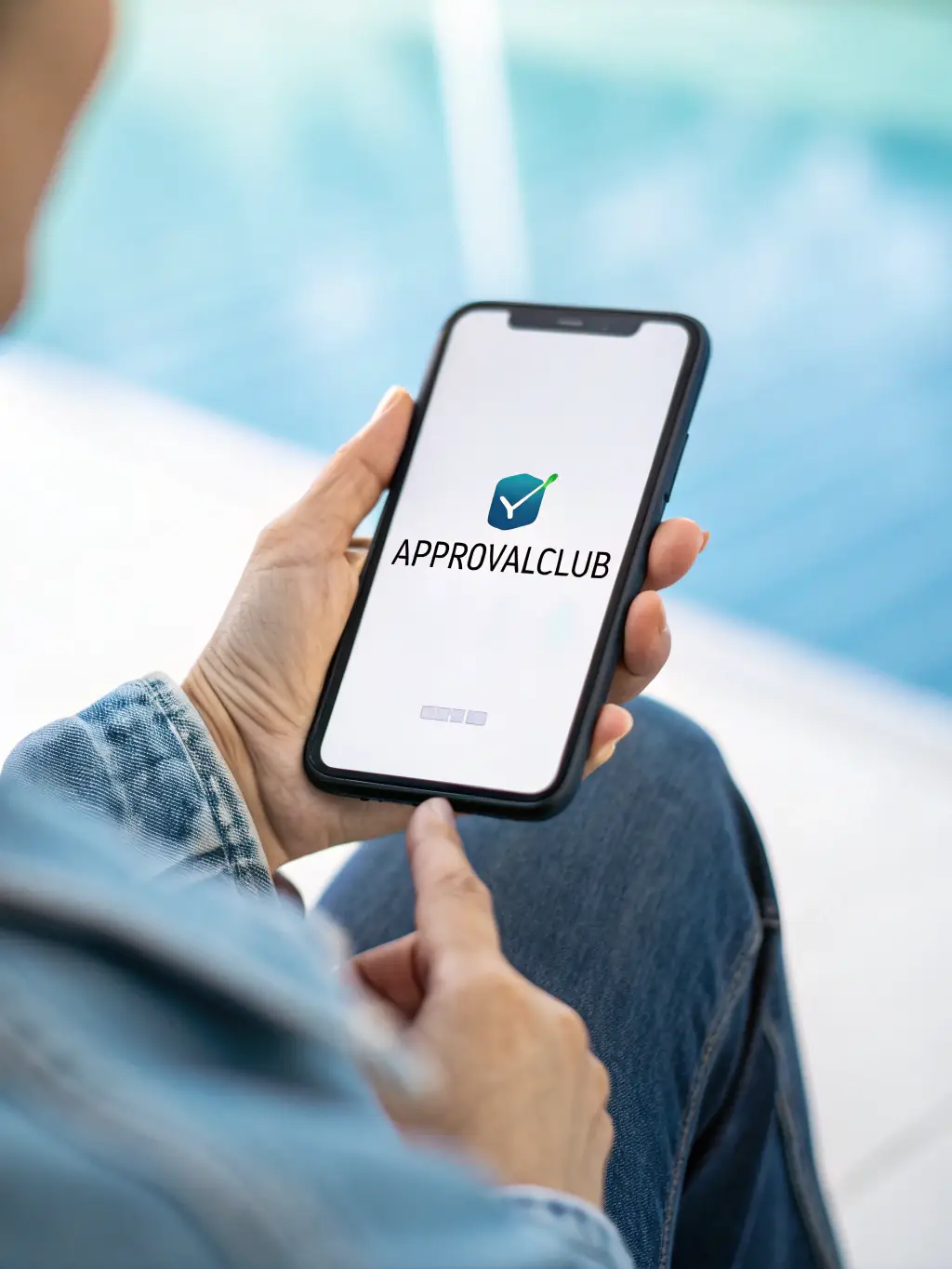 A photographer receiving an email notification on their phone confirming their funding approval, with a look of relief and satisfaction.