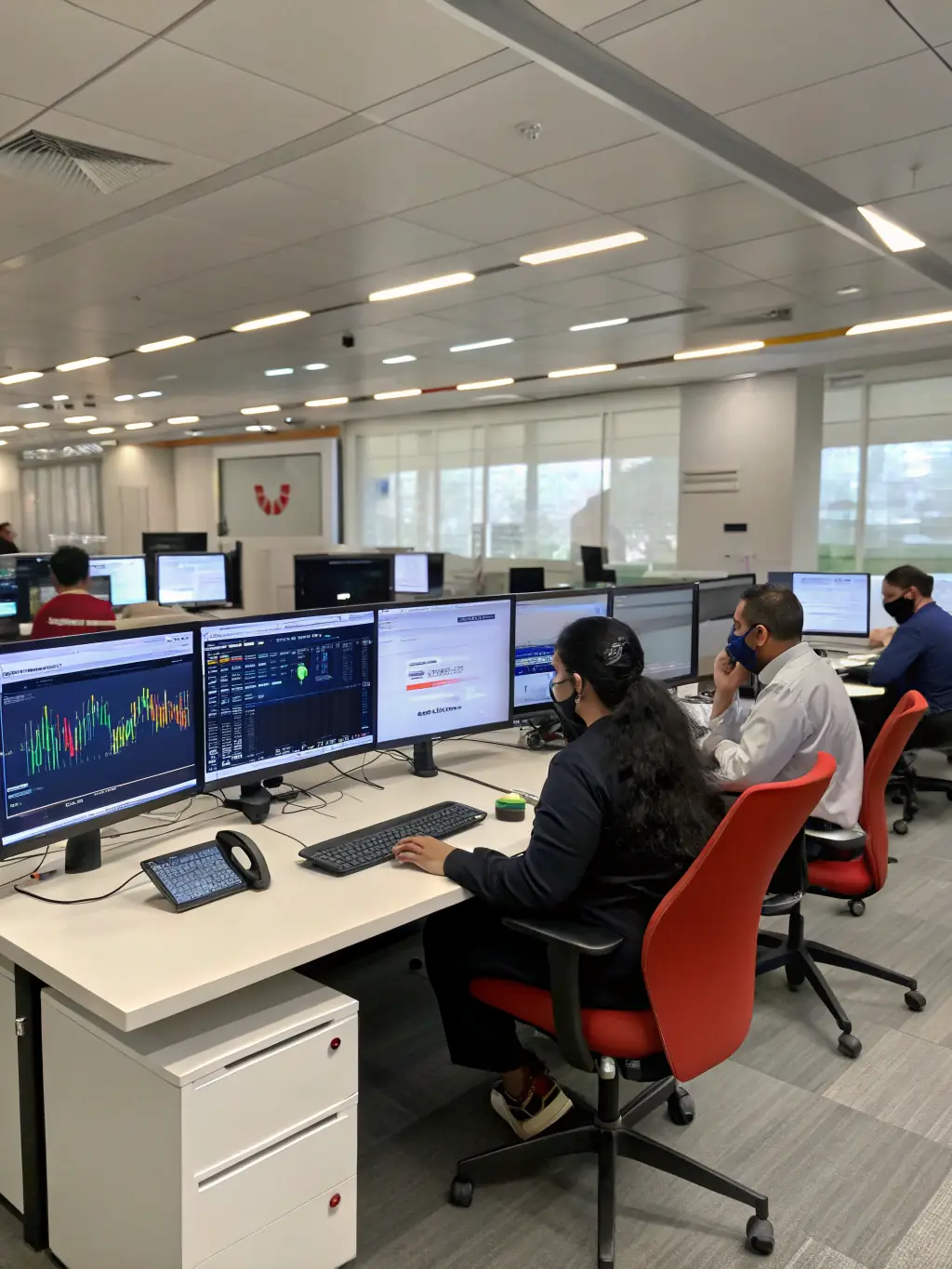 A modern telecom office with employees working on computers, representing Mulah's support for technological advancements.